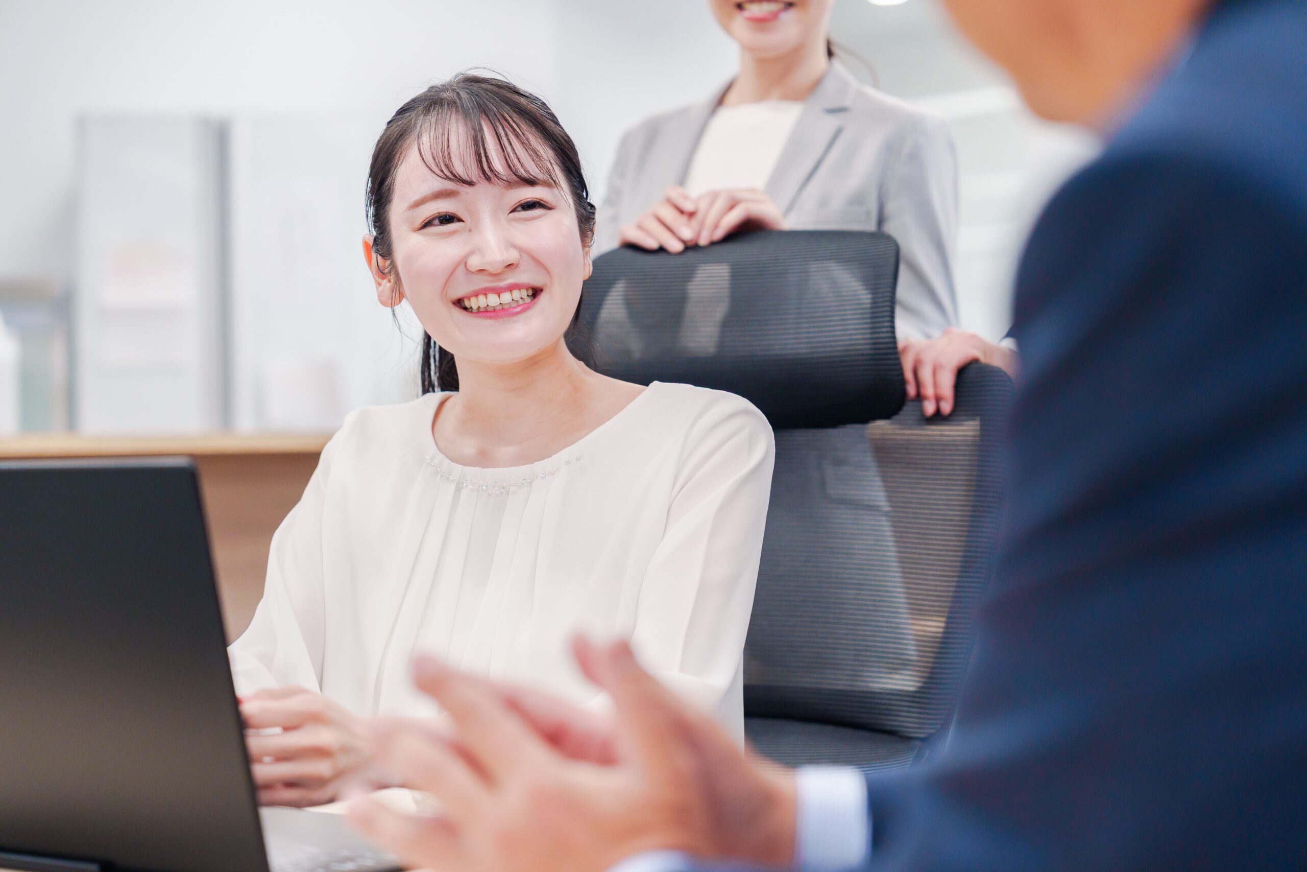 仲間との打ち合わせで笑顔を見せるクリエイターのイメージ